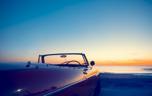 Convertible at the beach at sunset or sunrise.